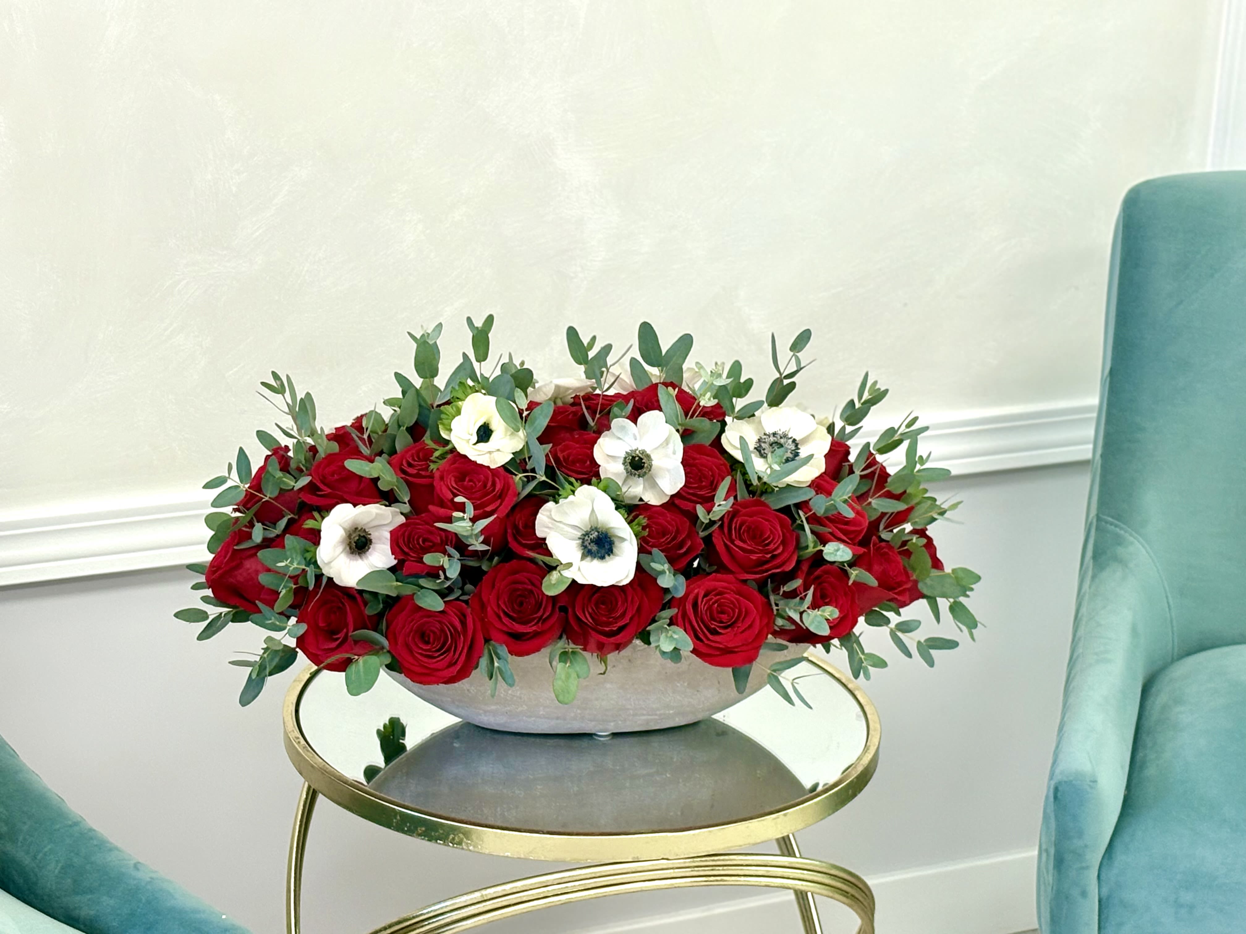 Red roses and white anemones in a low gray bowl
