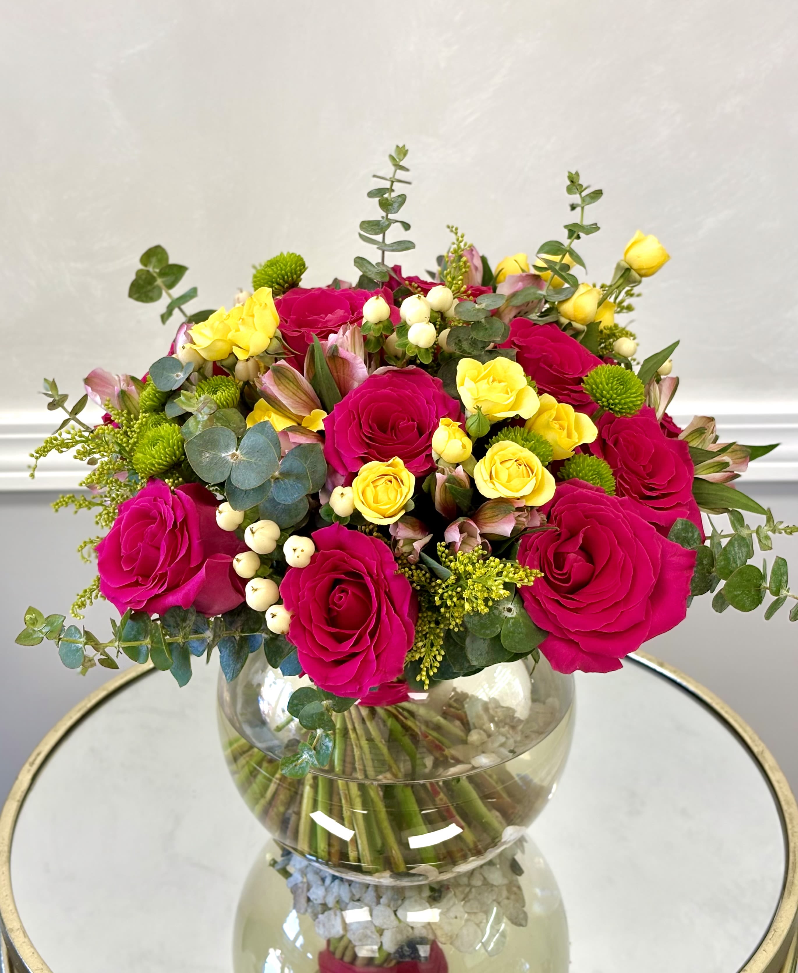Citrus Rose Garden By VLM Flowers - A vibrant and joyful arrangement featuring bold hot pink roses, cheerful yellow roses, delicate blooms, and fresh green accents. Designed with eucalyptus, textured greenery, and seasonal touches, this colorful bouquet brings a lively burst of happiness and elegance to any space. Perfect for celebrating special moments or adding a bright touch of beauty to the home.