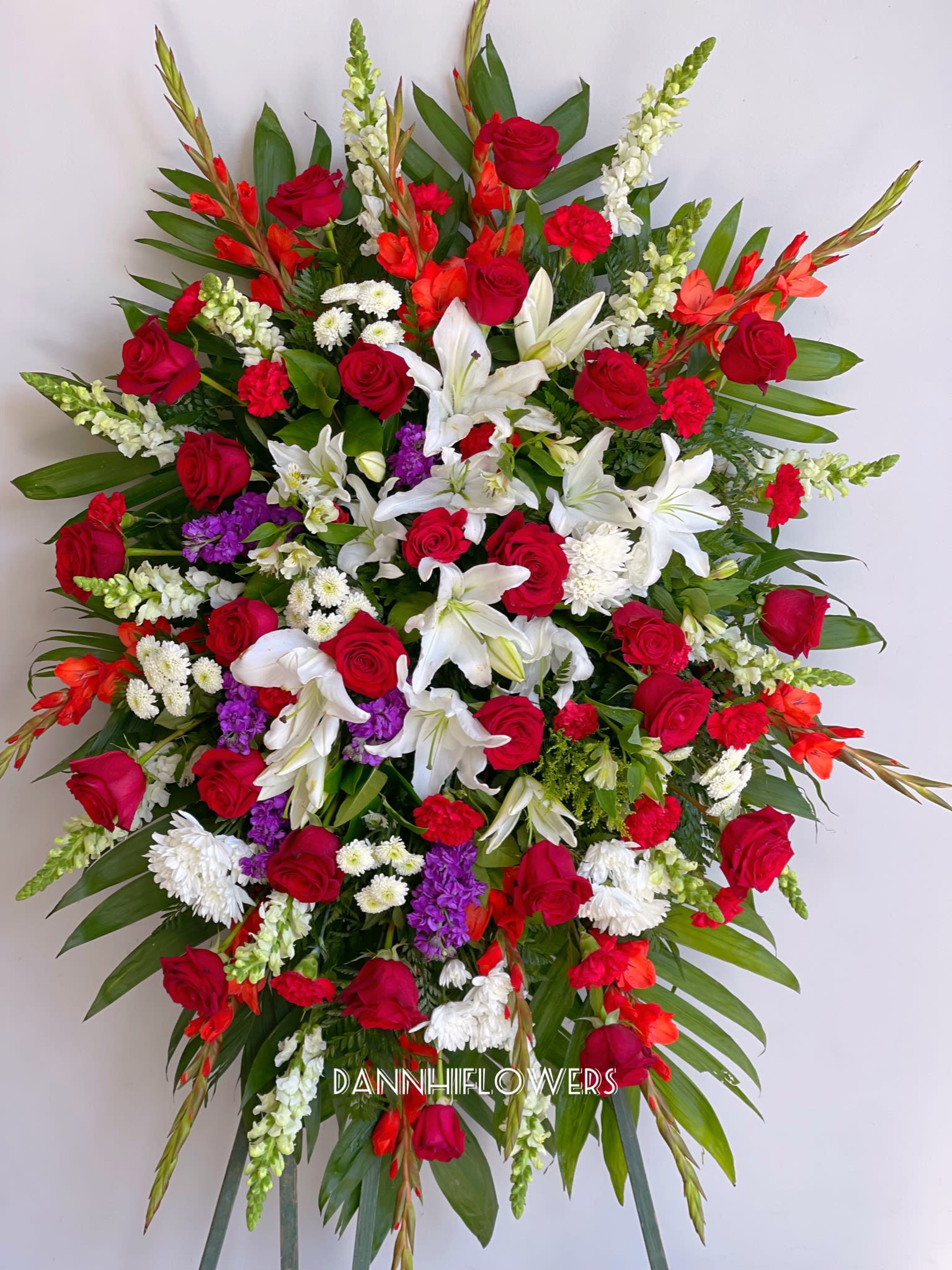 Large standing spray of red, white, and purple flowers