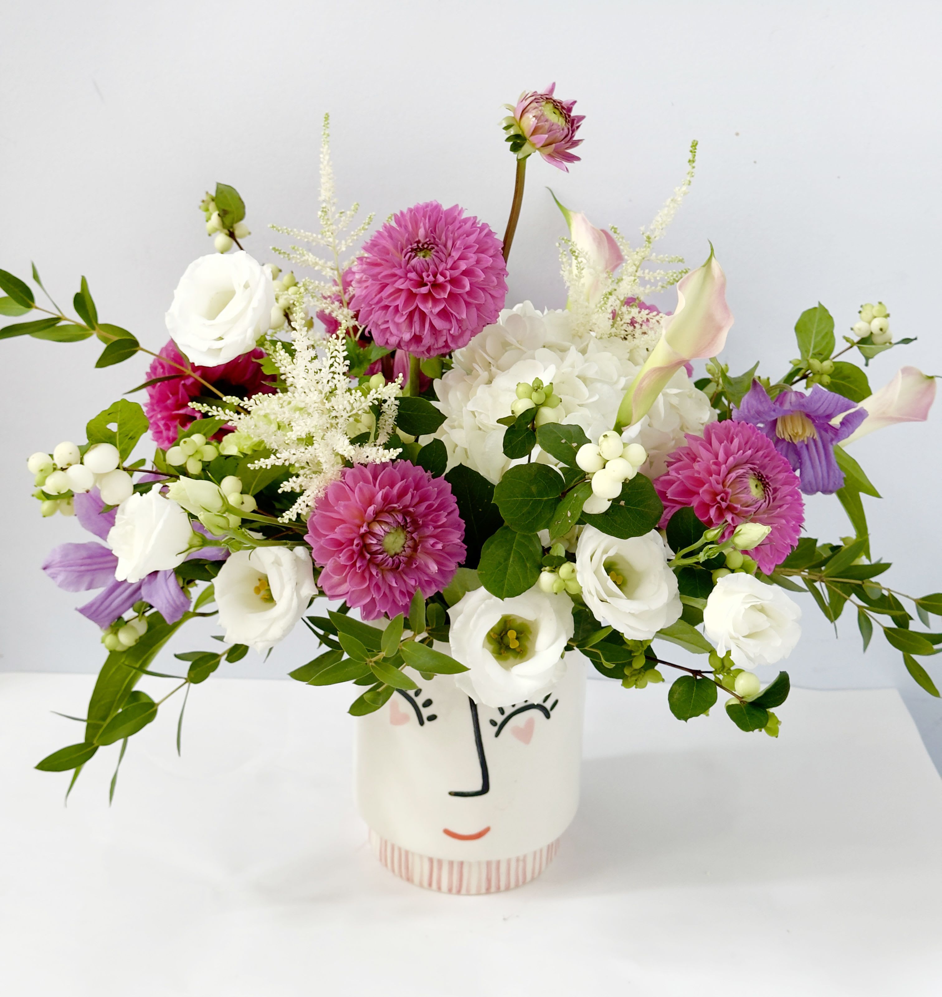 Smile &amp; Dahlias - This arrangement features white and pink color, airy looking arrangement with a very unique smile face vase 