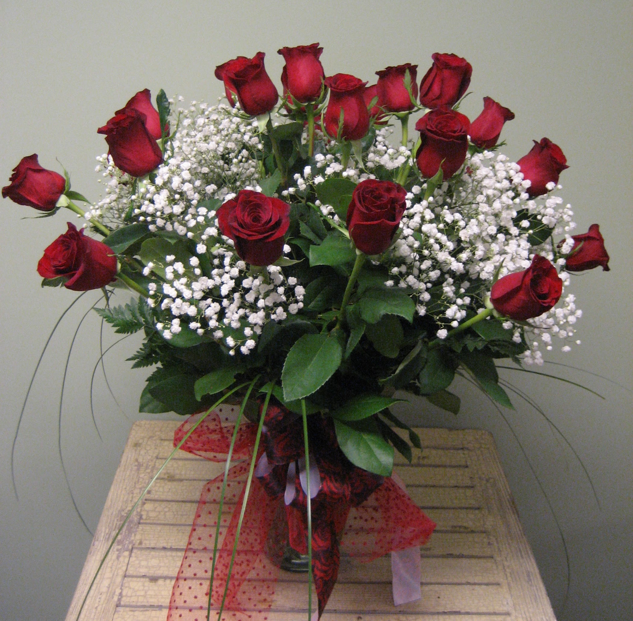Bouquet of red roses with white baby's breath in a glass vase