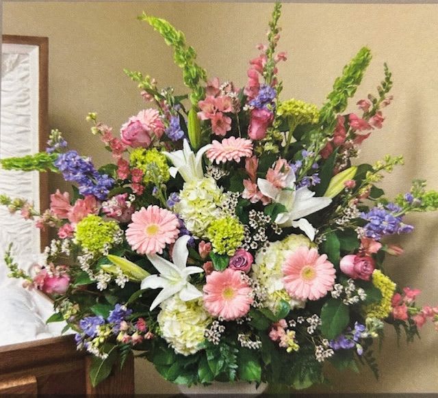 Large mixed floral arrangement with pink, white, purple, and green blooms