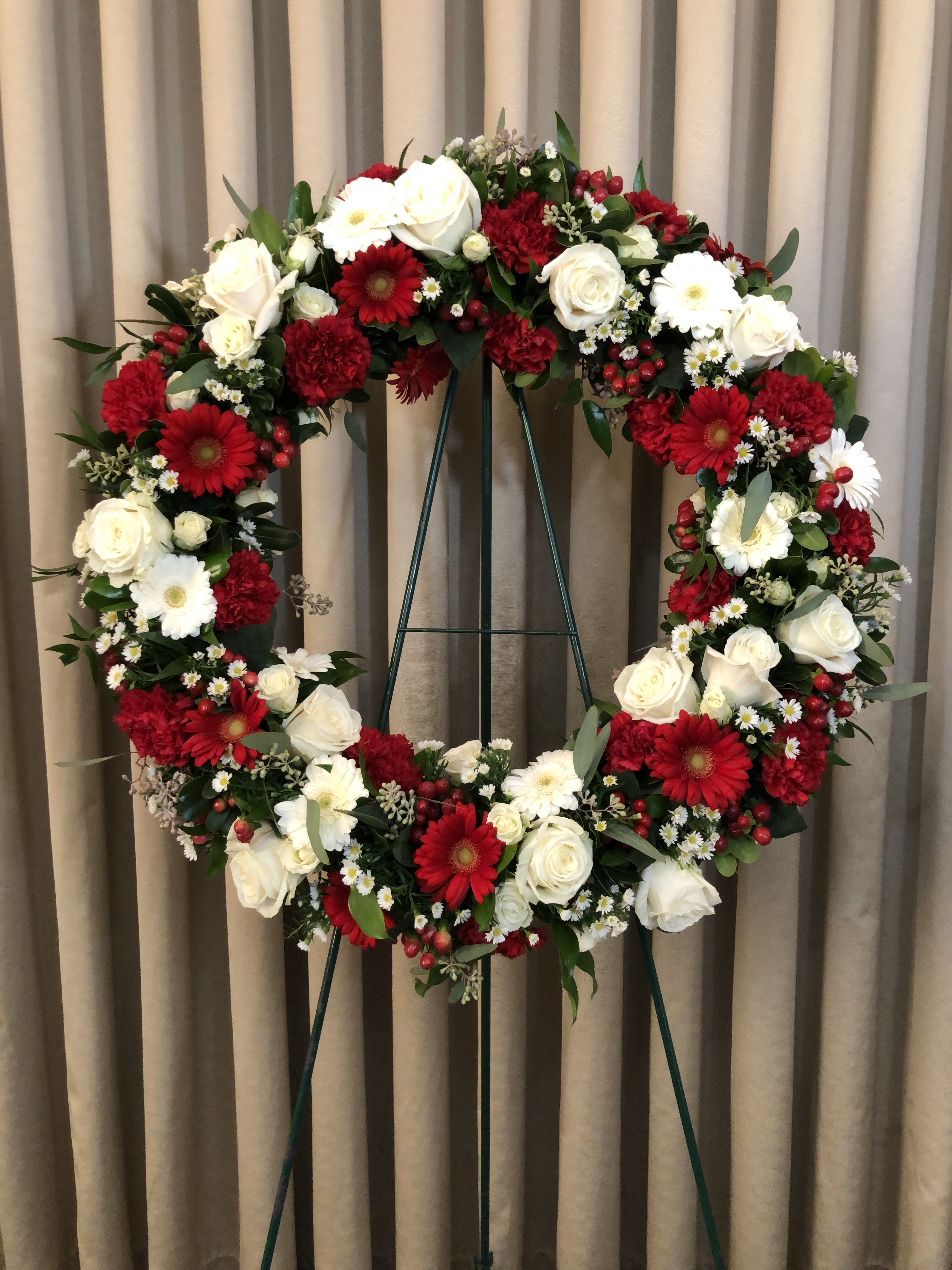 Red &amp; White Wreath W14 - This lovely wreath tribute piece is designed in shades of red and white flowers. Upgrading to Deluxe or Premium will add more flowers to your design