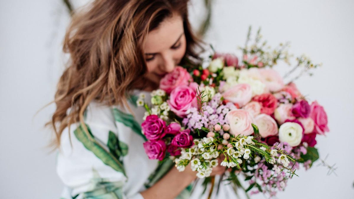 Woman holding a bouquet of pink and white roses