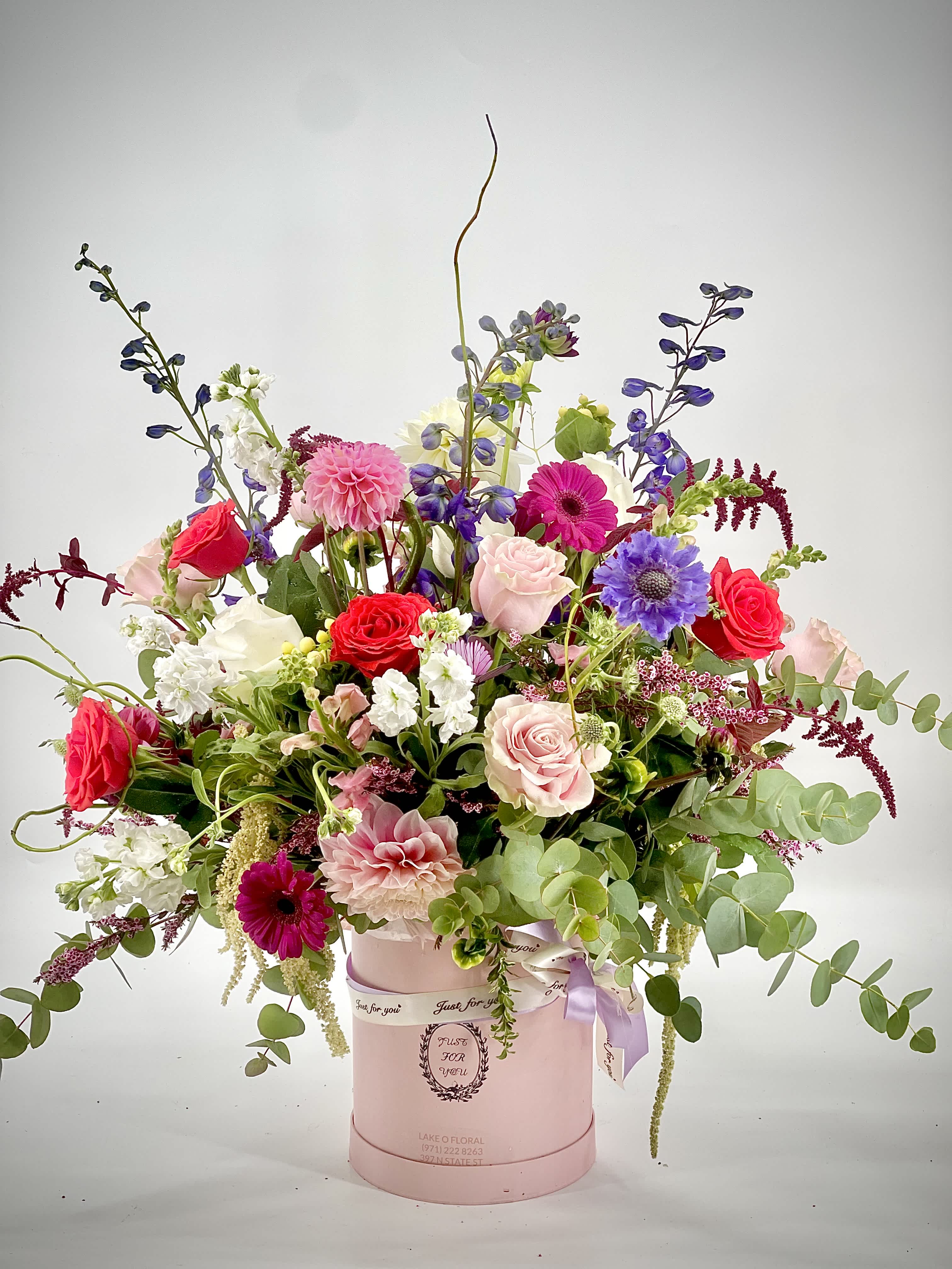 Mixed bouquet in a pink hat box with roses and gerbera daisies