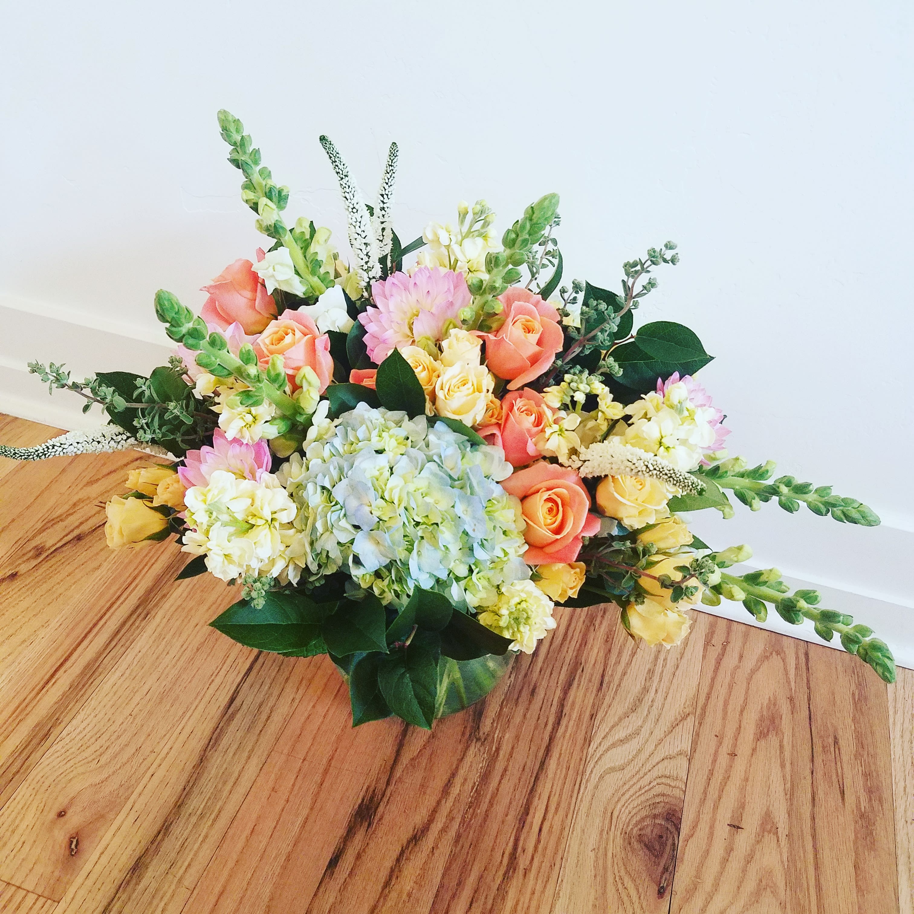 Mixed bouquet with peach roses, pale hydrangea, and pastel flowers