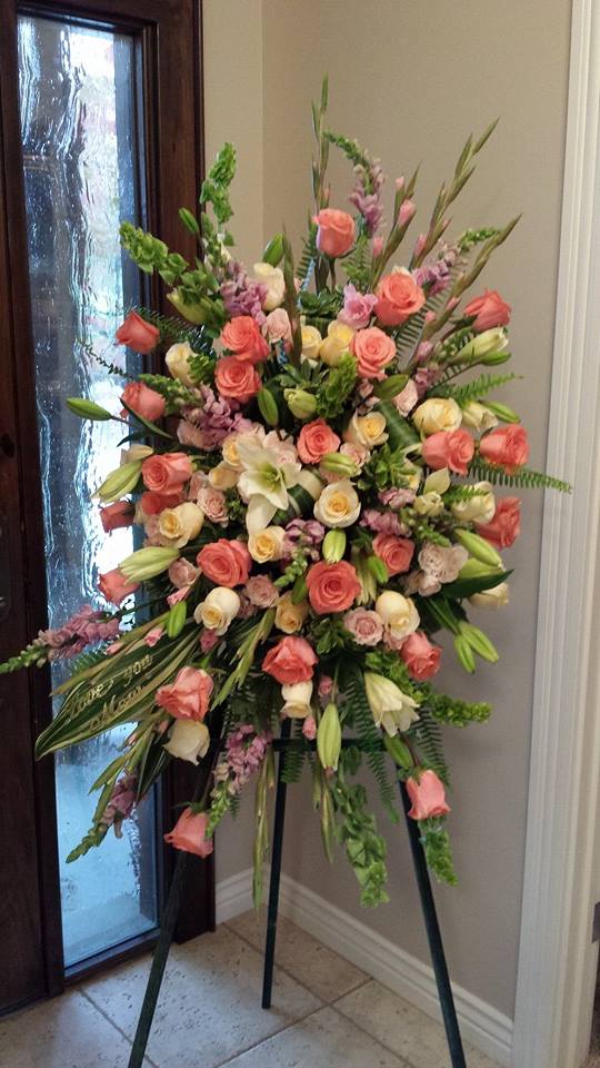 Large standing floral spray with pink and cream roses on an easel
