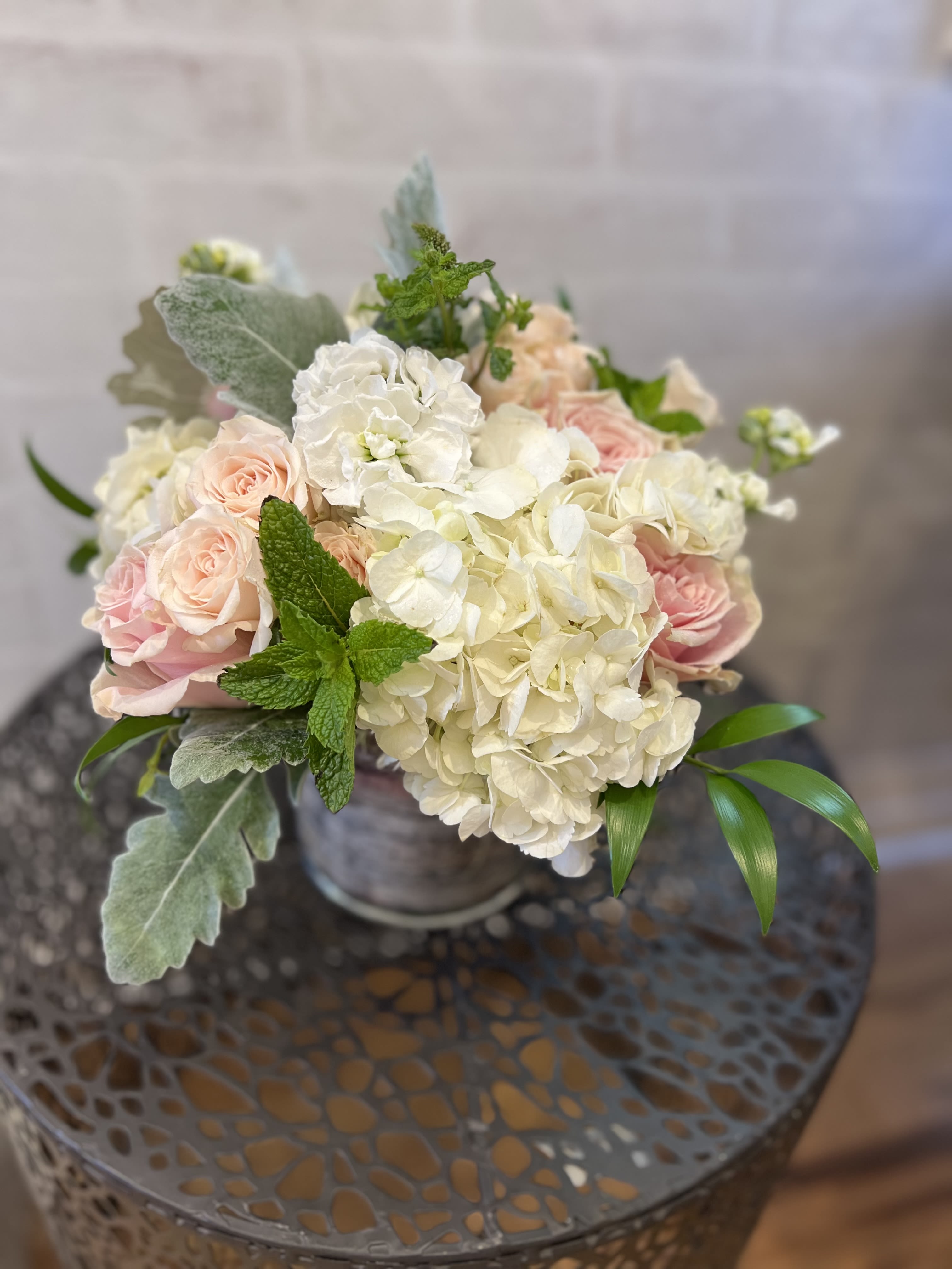 Bouquet of pale pink roses and white hydrangeas in a metal vase
