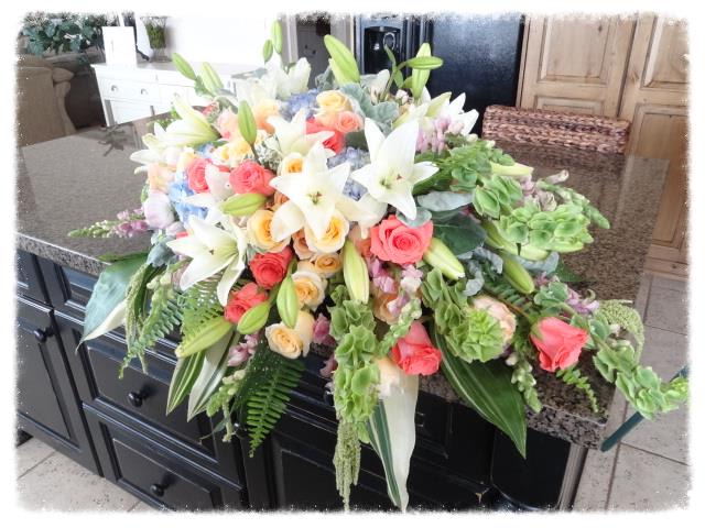 Garden Grandeur Casket Spray - For the lover of all things beautiful, this garden grandeur casket spray is filled with fresh lillies, roses, hydrangea, bells of ireland and more. A lovely tribute