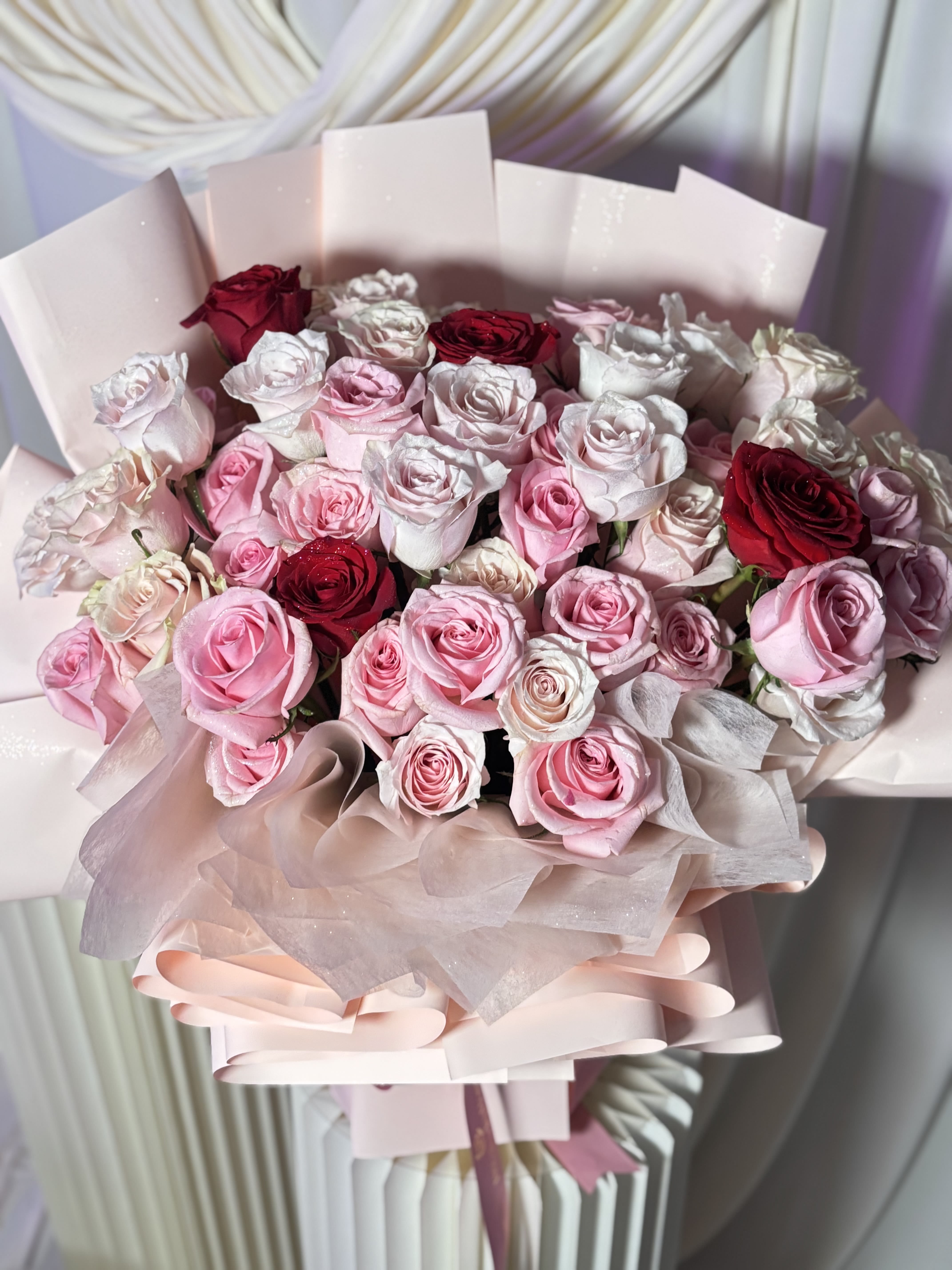Princess Bloom  - A romantic luxury bouquet featuring premium blush, ivory, and soft pink roses wrapped in our signature elegant presentation style.  Designed with soft feminine tones and layered luxury wrapping, this bouquet is perfect for birthdays, anniversaries, graduations, or celebrating someone special in the sweetest way   (Optional add-ons such as a teddy bear, chocolates, or custom letter/number details not concluded)  ———may be added separately to create an even more personalized gifting experience.  Please note: Flower substitutions and shades may vary based on seasonal and market availability. Our designers will always maintain the overall color palette, freshness, style, and luxurious feel of the arrangement shown.