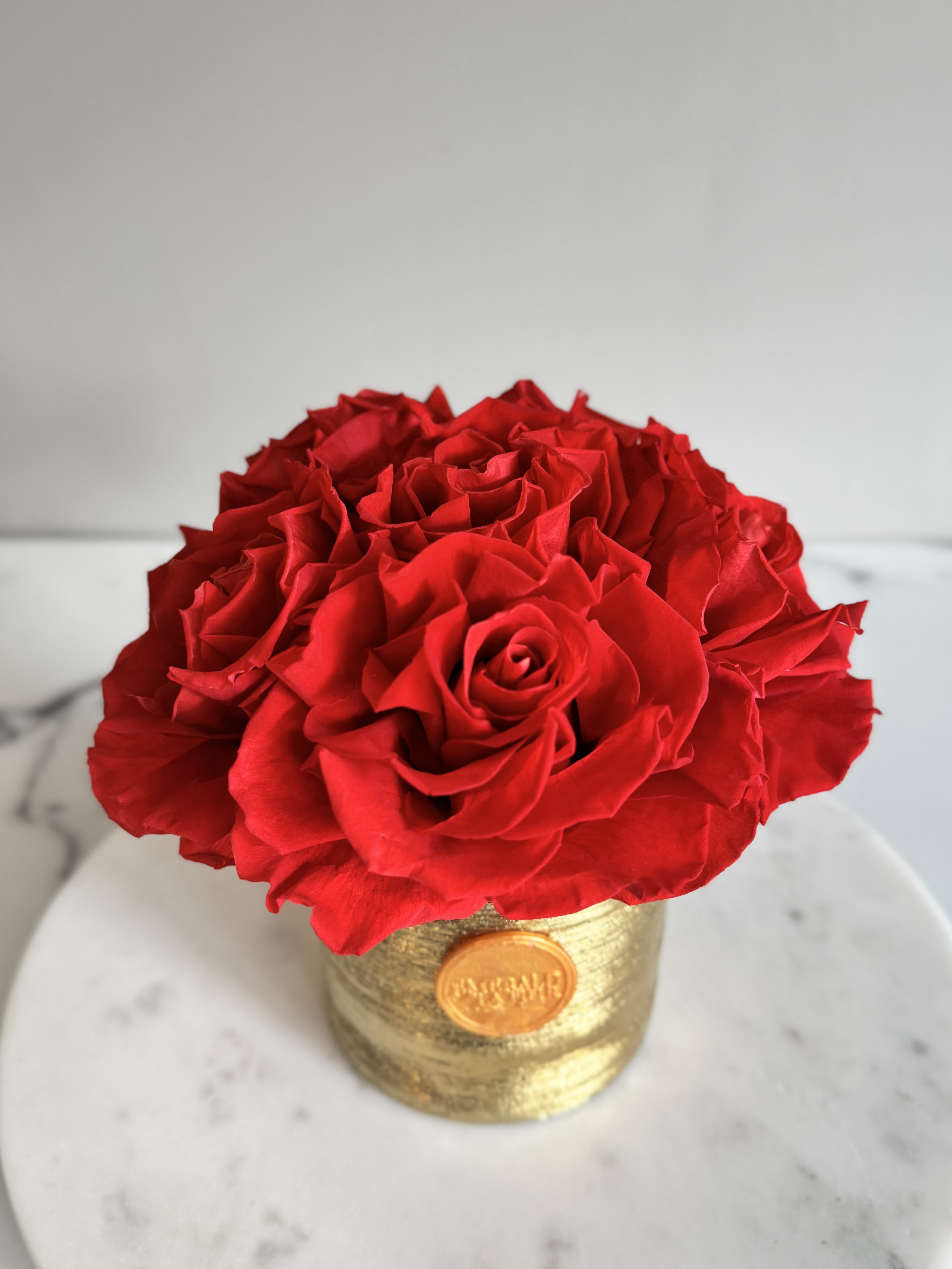Red rose arrangement in a gold container