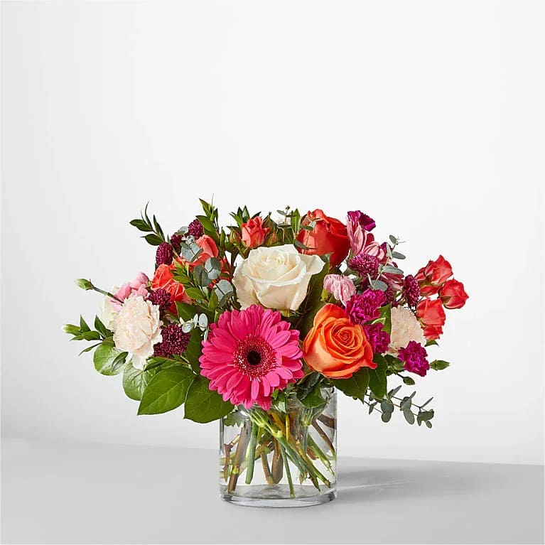 Smell the Roses Bouquet - Perfect for celebrating a milestone or simply sending your best wishes, this vibrant bouquet features bold hot pink and bright orange blooms that highlight the beauty of nature. The Deluxe Bouquet measures approximately 12" H x 15" W. It is professionally arranged by florists and arrives ready for display. To keep the flowers fresh longer, change the water daily and trim the stems every couple of days. Pet Safety Note: Some flowers and greenery in this arrangement may be toxic to pets, so please keep it out of their reach to ensure their safety. 