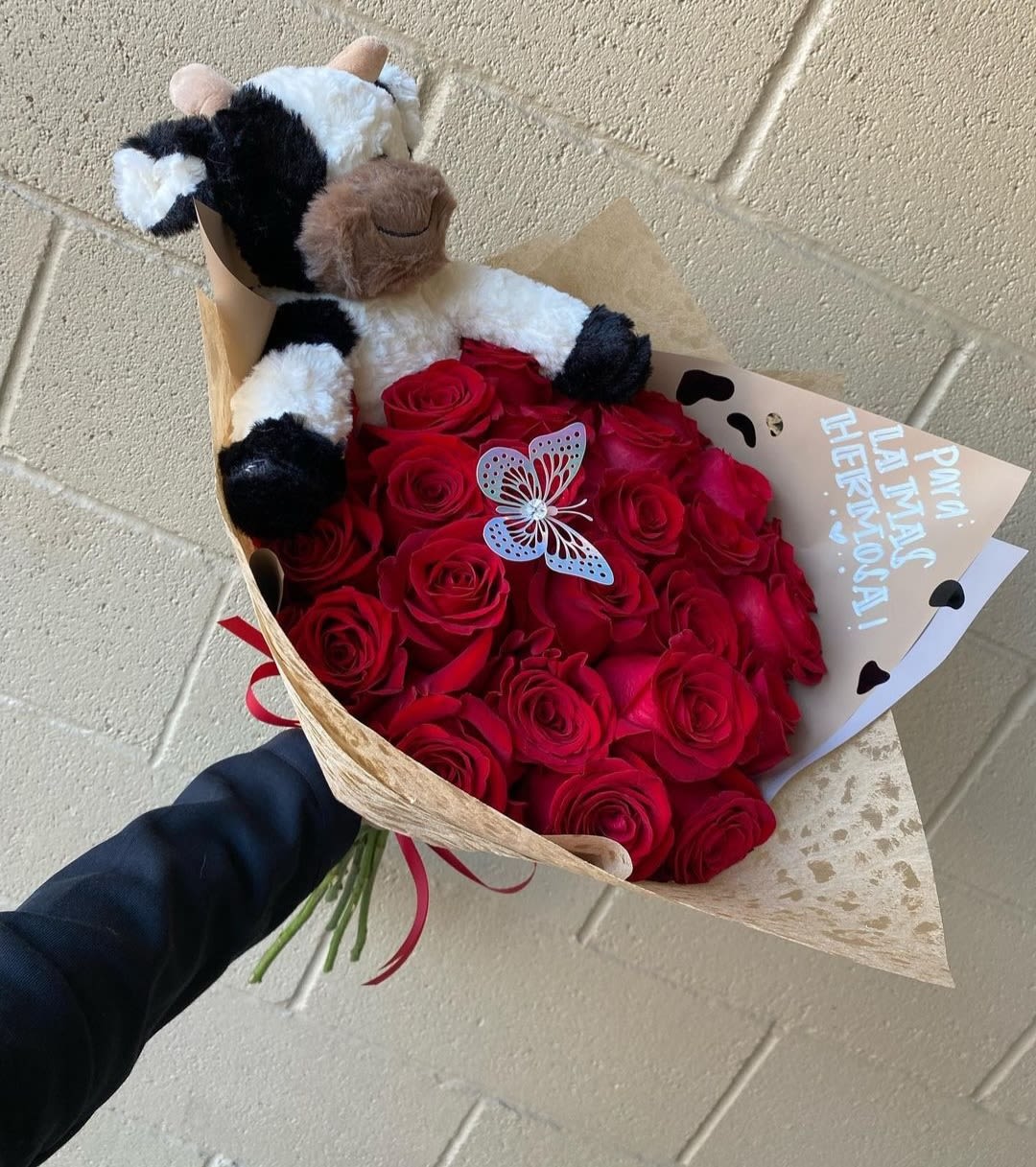 Bouquet of red roses with a plush cow and butterfly topper