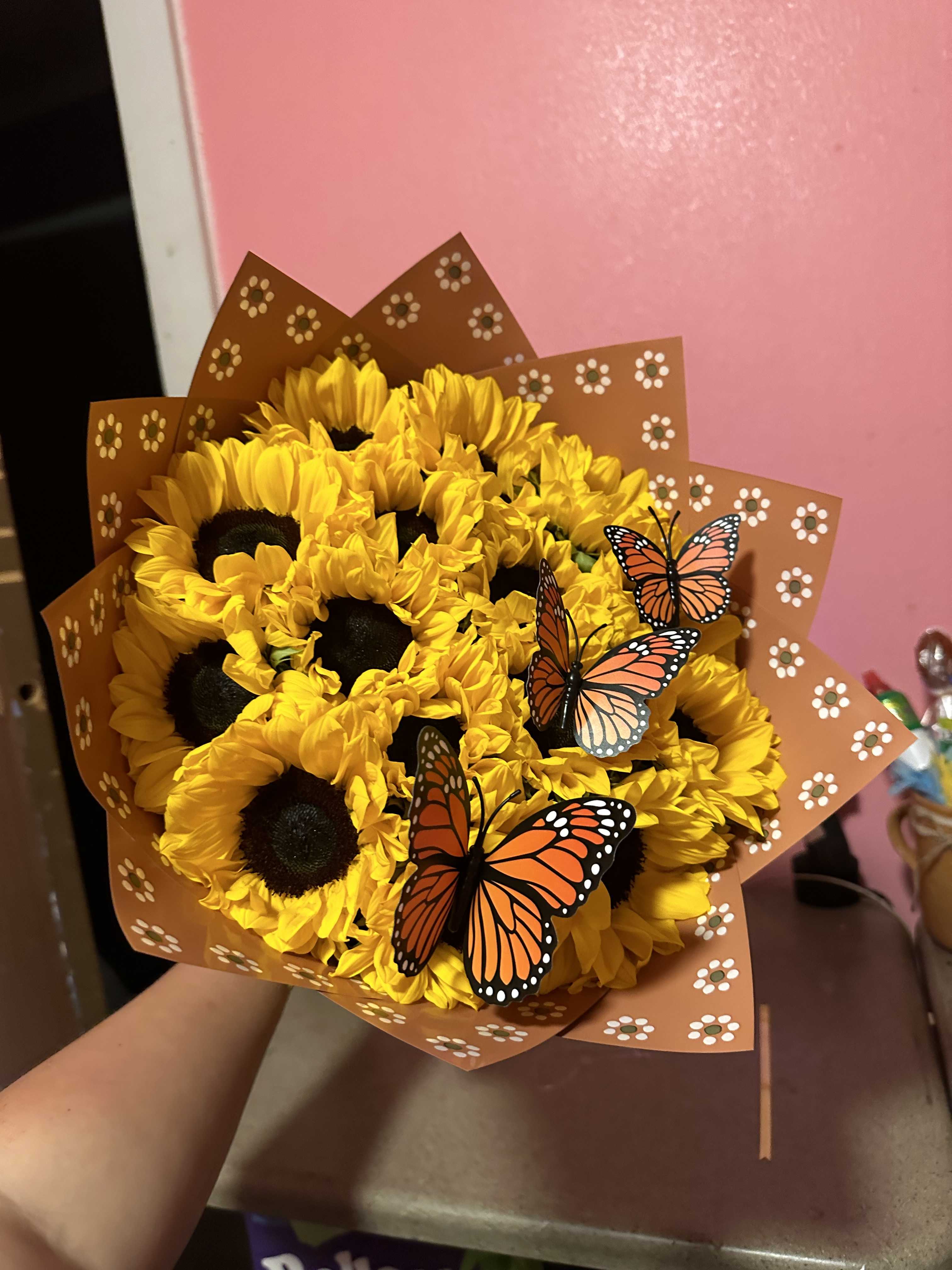 Bouquet of yellow sunflowers wrapped in brown paper with butterfly decorations