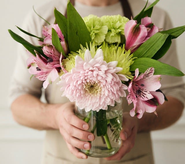 Sweet Garden mix - A soft, garden-style arrangement that reads like a sweet bouquet picked from a spring bed-perfect as a thinking-of-you gift or a gentle way to say I'm sorry. This flower arrangement for occasions like Mother's Day, Best Friends Day, or a springtime anniversary centers on white, purple, pink, and green blooms to create a fresh, uplifting presence for the person you're sending it to.  The compact mix pairs pale pink and lime-green chrysanthemums with pink alstroemeria, dahlias, carnations, and lush green foliage for layered texture and a cheerful palette. A large pale pink chrysanthemum anchors the front while lime-green mums and alstroemeria provide contrast and delicate detail; the broad green leaves frame the arrangement for a full, garden-like silhouette. Arranged in a clear glass vase, it arrives ready to display on a bedside table, office desk, or mantel.  Made to comfort, celebrate, or simply say thank you, this arrangement suits everyday gifting, spring gatherings, Labor Day tables, Father's Day gestures of appreciation, sympathy and funeral settings, or casual "just because" moments. Care is simple: fresh water in the vase keeps stems vibrant-replace water as needed and trim stems occasionally to prolong bloom life.