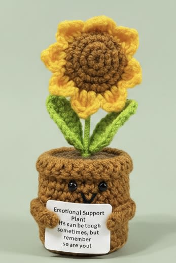 Emotional Support Sunflower - A handmade crocheted sunflower that doubles as a cheerful desk companion - perfect as a novelty gift or "just because" pick-me-up. This flower arrangement for gifting brings sunny yellow petals, a warm brown textured center, and two green leaves together in a playful, character-shaped pot, making it a lighthearted choice for birthdays, new jobs, or to brighten someone's day.  The piece is crafted from soft yarn and presented in a matching crocheted pot with little eyes and arms for personality. A small white sign tucked in front reads "Emotional Support Plant," giving the arrangement a comforting, whimsical message that will make the recipient smile. Neutral white and green accents keep the look fresh and versatile for any desk, shelf, or bedside table.  Designed as a long-lasting, low-maintenance keepsake rather than live flowers, this sunflower is ideal for the person you want to cheer up, encourage, or celebrate without the need for watering or care. Its compact size fits easily on workstations and small spaces-order when you want a durable, uplifting gift that feels thoughtful and handmade.