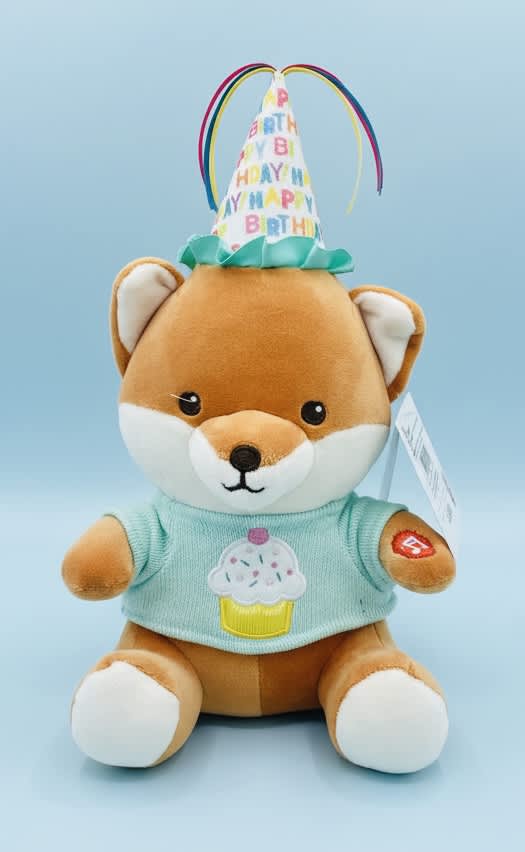 Plush fox wearing a birthday hat and cupcake shirt