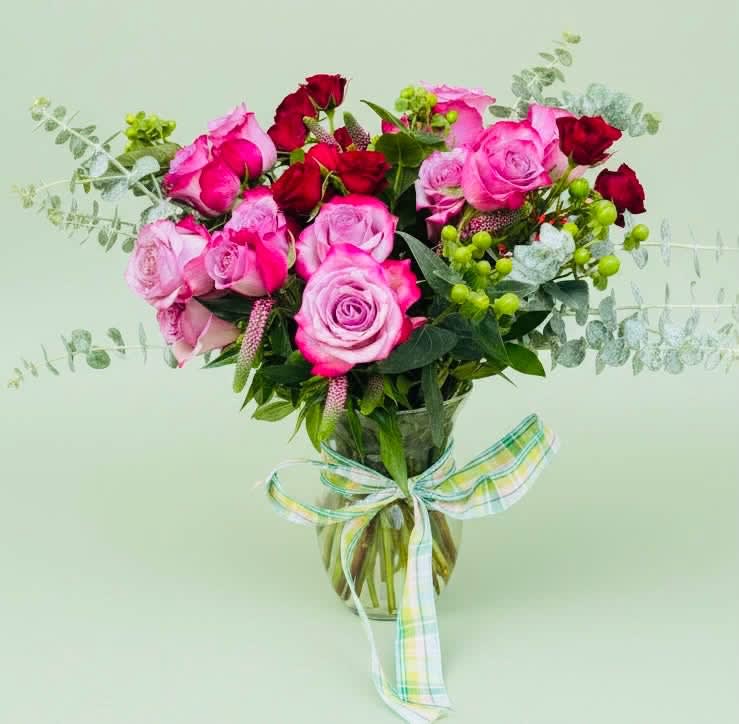 Bouquet of pink and red roses in a glass vase with a ribbon