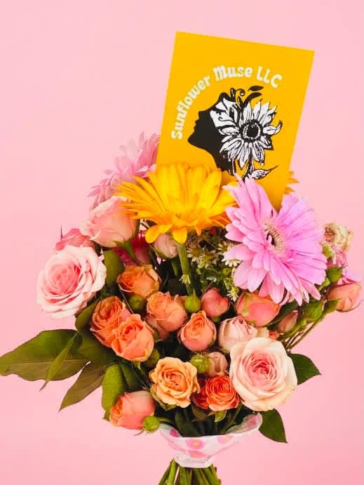 Bouquet of pink and peach roses with gerbera daisies and a yellow card