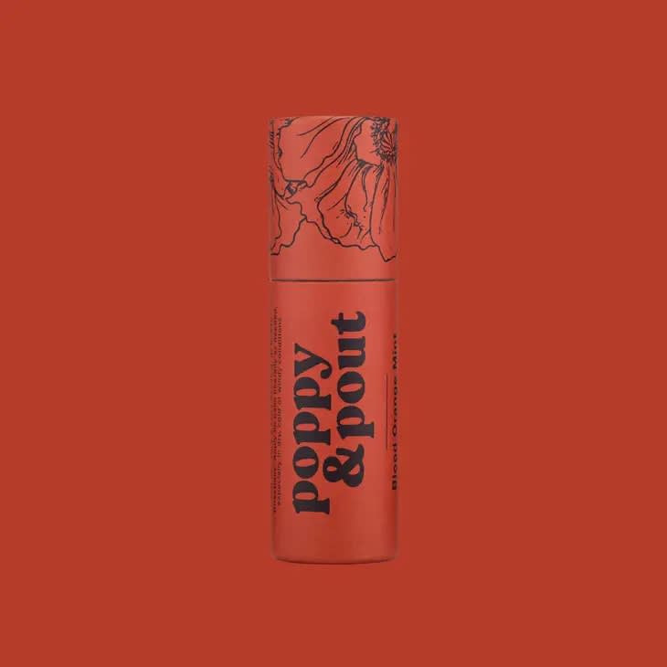 A coral lipstick tube with floral line art and bold text