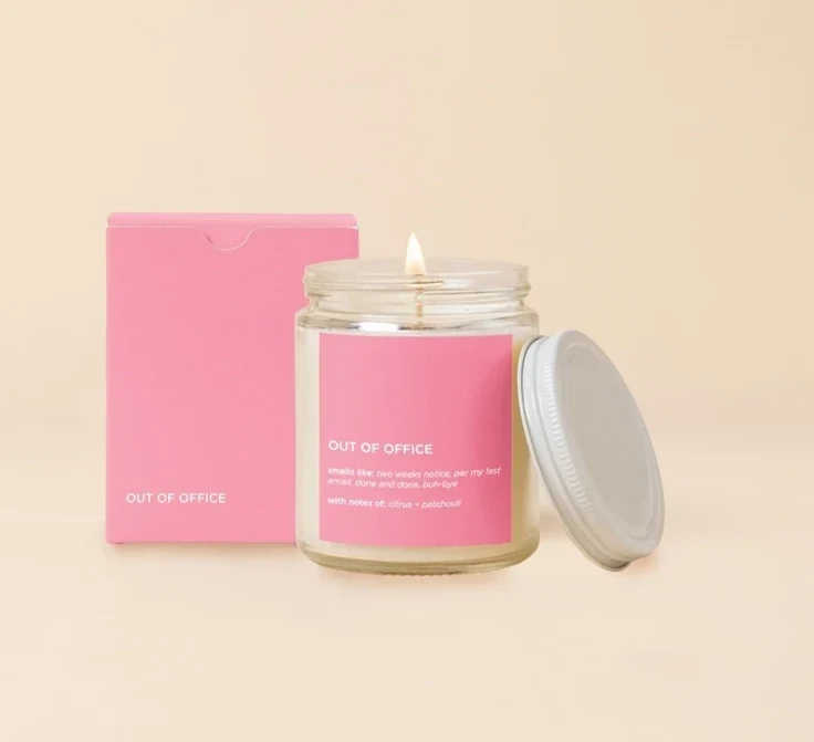 Lit candle in a glass jar with a pink box and lid