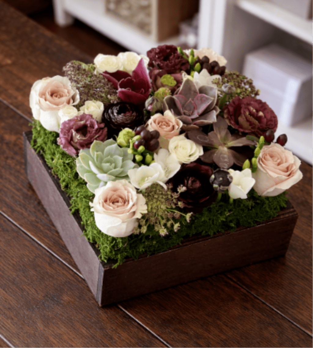 Succulent and rose arrangement in a wooden box