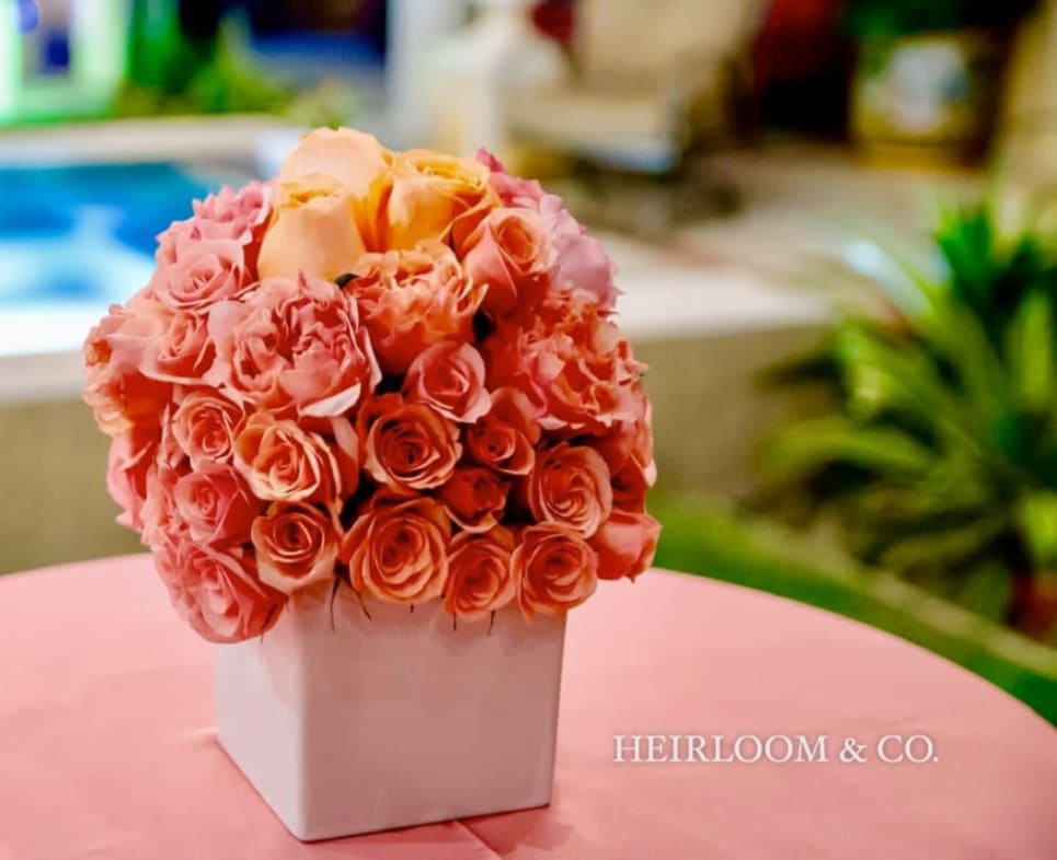 Peach and pink rose bouquet in a white square vase