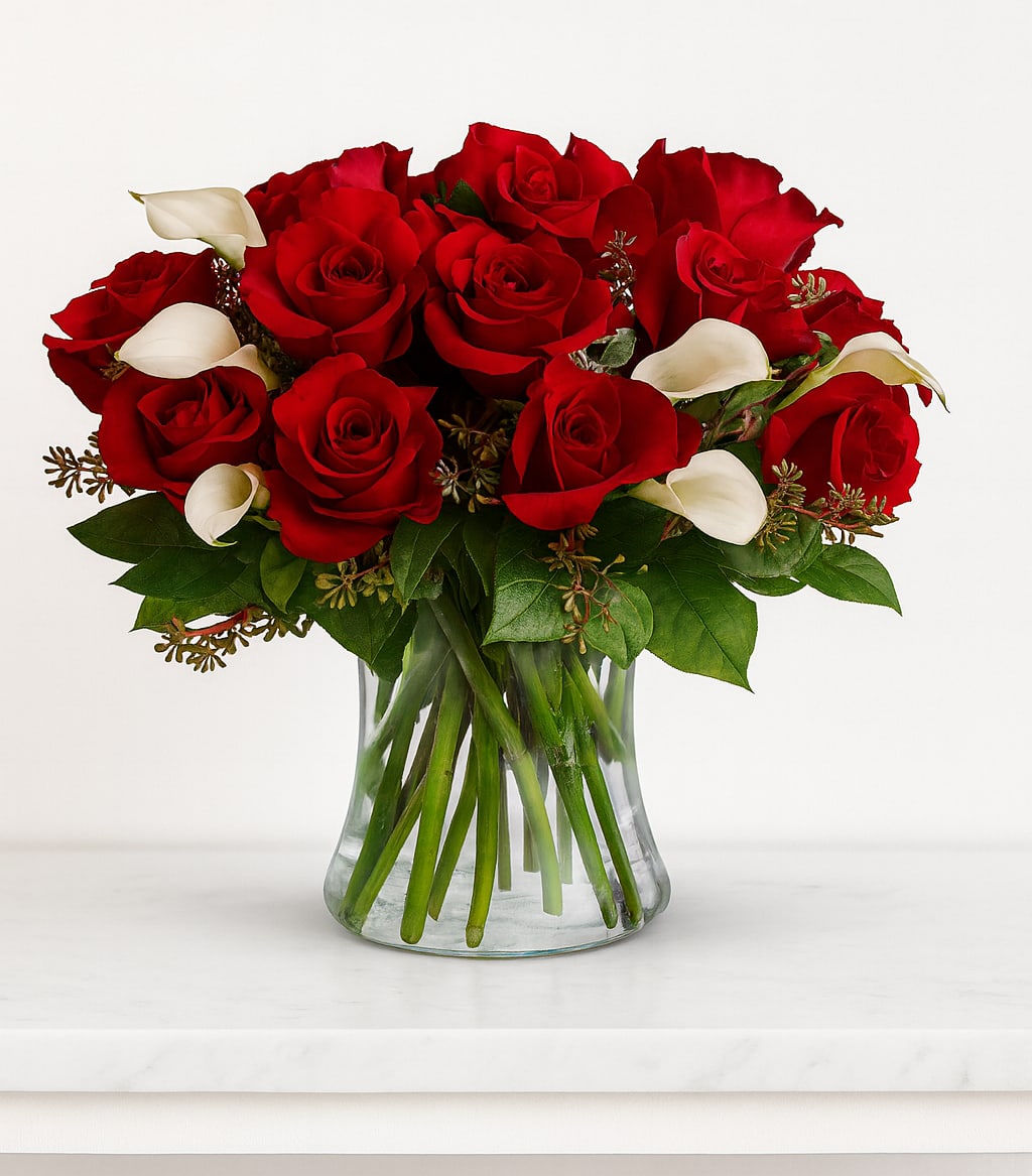 Be Still My Heart - Dozen Red Roses  - The look of love is charmingly reflected in this romantic array of red roses and fragrant white callas. Beautifully presented in a sparkling glass vase, these gorgeous flowers will say what's in your heart more eloquently than words.  The gorgeous bouquet features one dozen red roses and a half dozen miniature white calla lilies accented with assorted greenery.  Approximately 15 1/2" W x 15 1/2" H  Orientation: All-Around      As Shown : TRS02-1A     Deluxe : TRS02-1B     Premium : TRS02-1C 