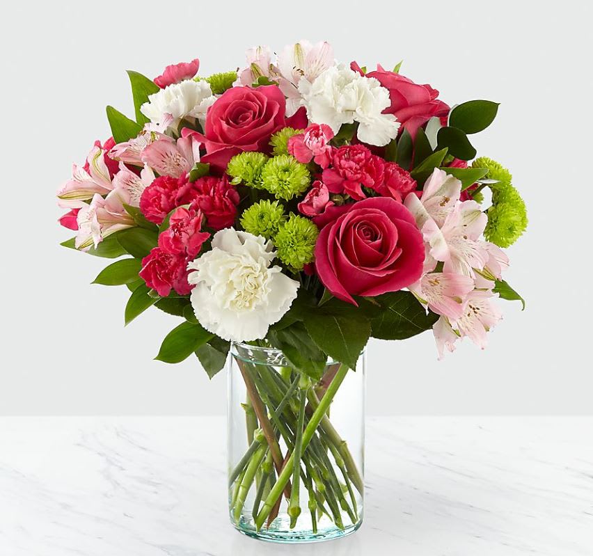 Bouquet of pink roses, carnations, and alstroemeria in a clear glass vase