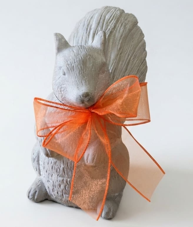Gray squirrel figurine tied with an orange sheer ribbon