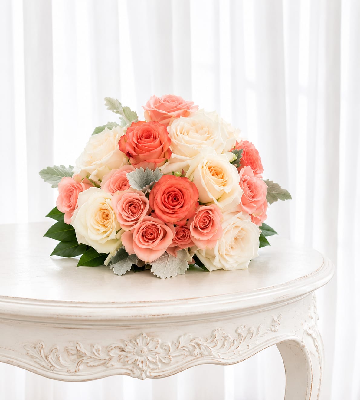 Peach bouquet - Soft coral and blush roses gathered in a compact, rounded wedding bouque to make her feel truly cherished. The peach bouquet's creamy ivory blooms and muted green accents give it a refined, airy look that reads intimate and elegant for moments when you want the recipient to feel celebrated and seen.  The arrangement features tightly clustered roses in coral, blush pink, and creamy ivory tones with a few silvery-green foliage sprigs peeking through at the base for texture and contrast. Its full, layered form sits neatly in a compact profile, ideal for tabletops or as a centerpiece without overwhelming the space. Sized to present a lush, refined silhouette, it brings soft color and gentle fragrance to any room.  This is the kind of bouquet that suits weddings, anniversaries, or a thoughtful "I'm thinking of you" surprise - she'll feel warmed by the romantic palette and classic rose shape. For best enjoyment, keep the stems in fresh water, trim them slightly before arranging, and place away from direct heat or drafts to extend bloom life.   If any design elements are of major importance to your order, please include them in the florist instructions at checkout or contact us to ensure availability.