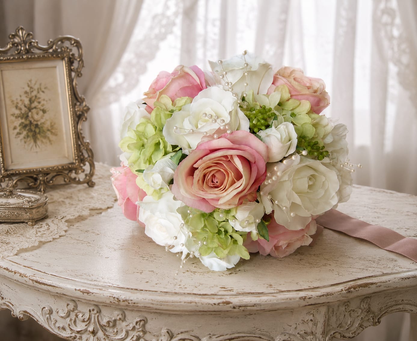 Bridal bouquet - A softly romantic bridal bouquet designed to make the bride feel cherished the moment she lifts it. This wedding bouquet features pink and white roses paired with pale green hydrangeas for a classic, vintage-inspired look-perfect for a wedding or anniversary where timeless elegance is the goal. The overall rounded, hand-tied shape reads intimate and feminine, ideal for ceremony photos and close-up moments.  Petal textures range from the plush fullness of hydrangea clusters to the satin-smooth rose blooms, while delicate pearl picks are woven through the arrangement for a subtle, heirloom sparkle. The stems are finished with a wrapped satin ribbon that complements the blush and ivory palette, giving the bouquet a polished grip and graceful trailing detail. Colors: pink, white, green; flowers: roses, hydrangeas, and coordinating fillers; hard goods: pearl picks and satin ribbon.  Made to suit a bride who loves soft, romantic styling, this bouquet sends a message of tenderness and refined beauty-she'll feel truly seen on her day. Sizes and exact stem counts are available at checkout; to keep blooms fresh, store in cool water and present to the florist shortly before the ceremony if any last-minute adjustments are needed.   If any design elements are of major importance to your order, please include them in the florist instructions at checkout or contact us to ensure availability.