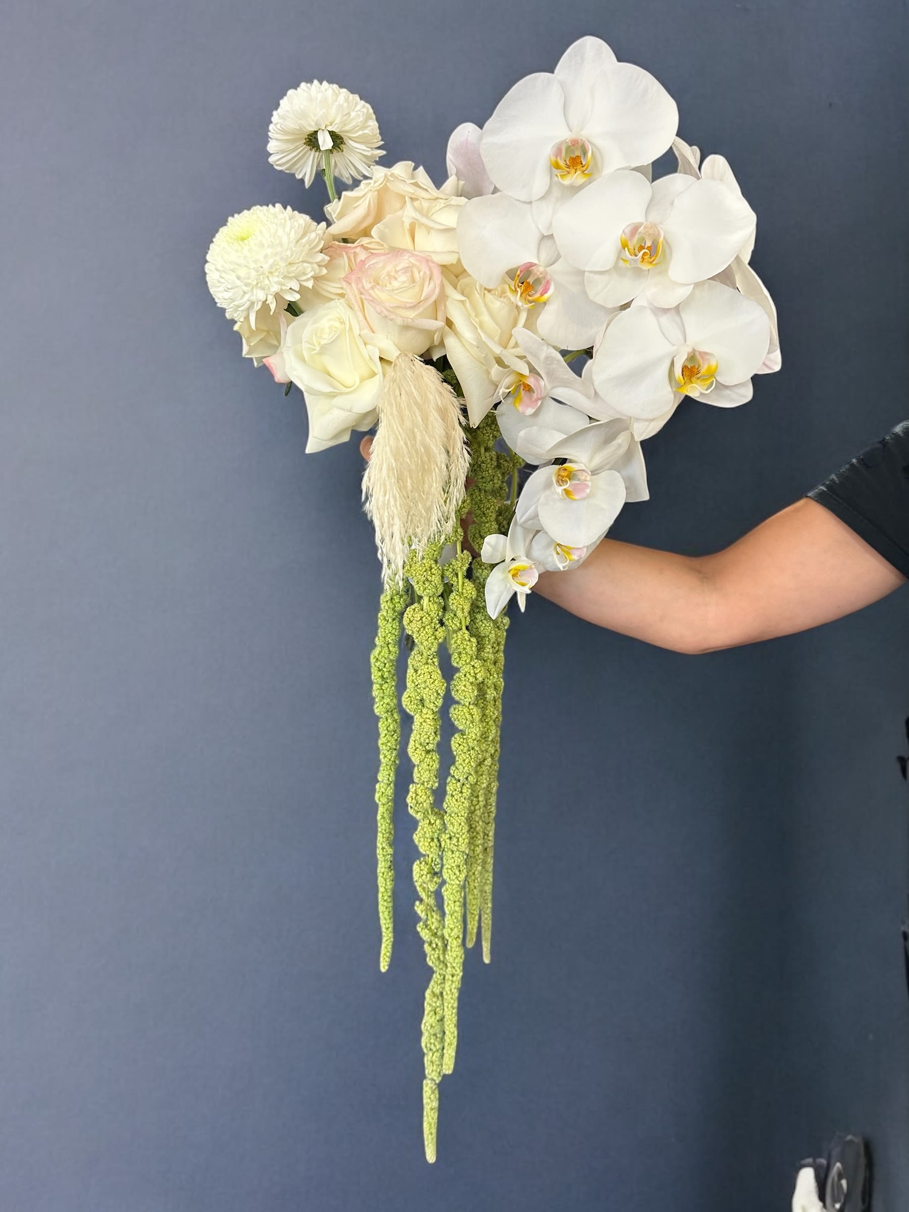White orchid and rose bouquet with long green hanging accents
