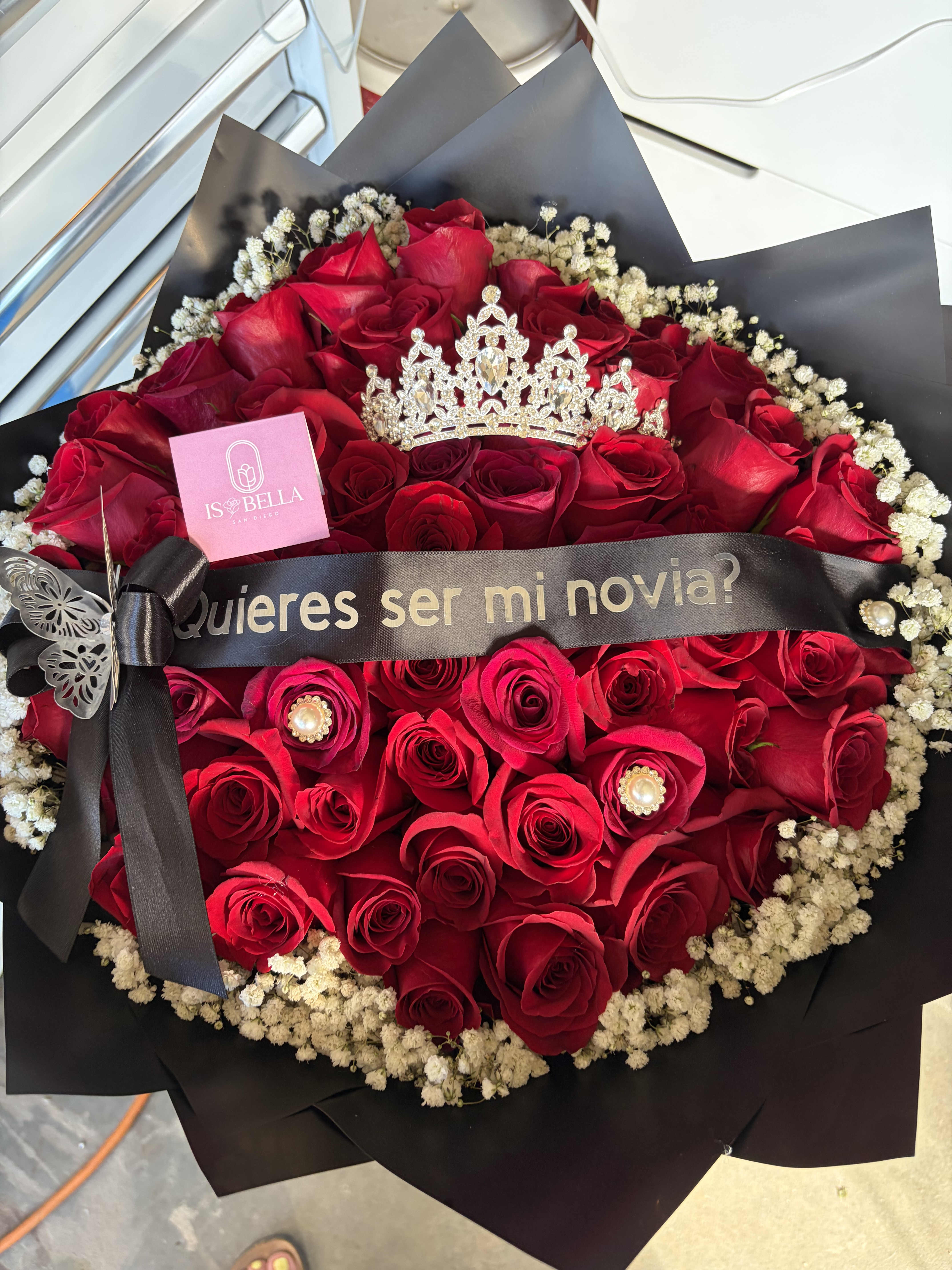 Bouquet of red roses with a black ribbon and crown topper