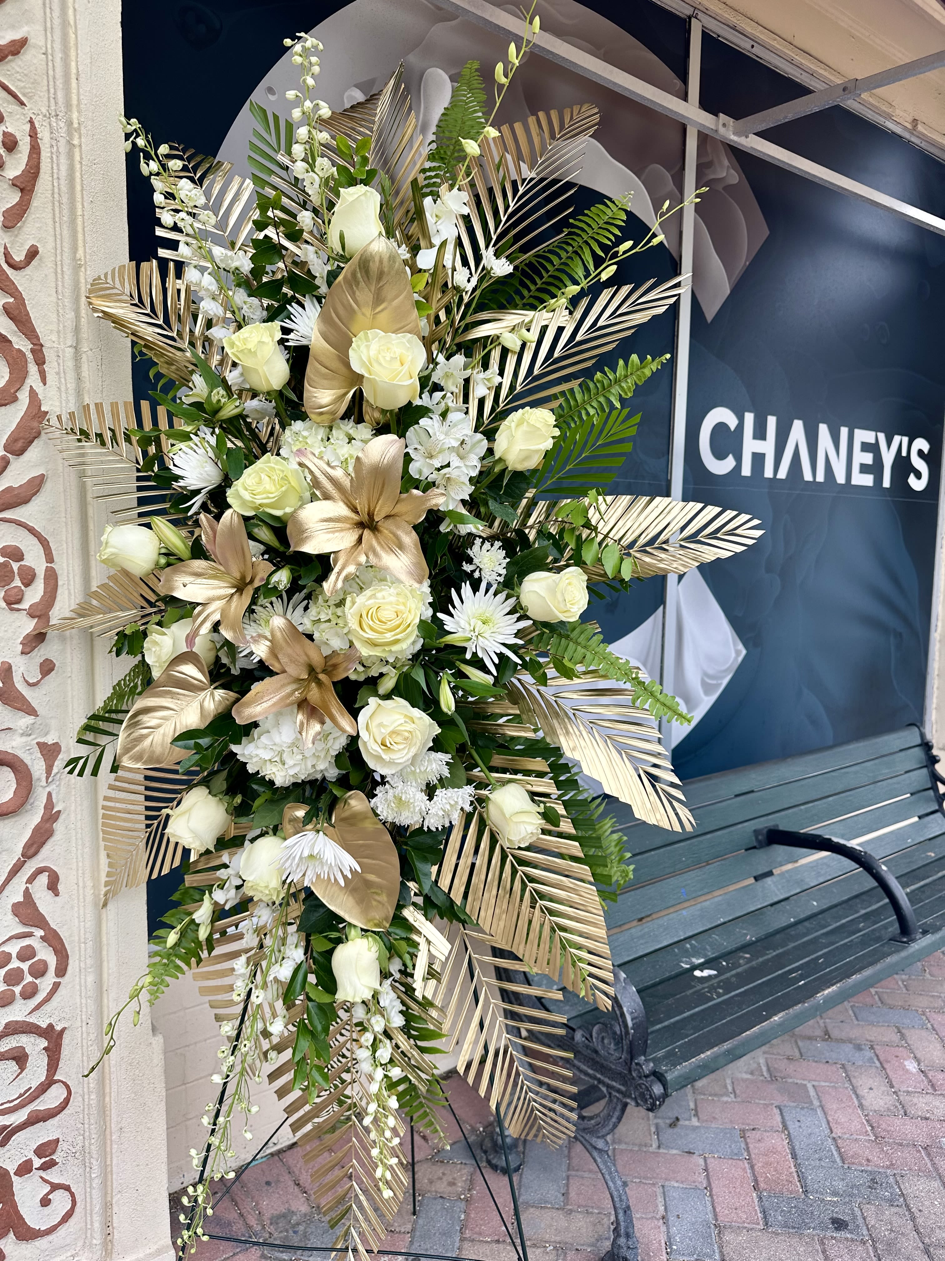 Tall white and gold floral standing spray with roses and lilies