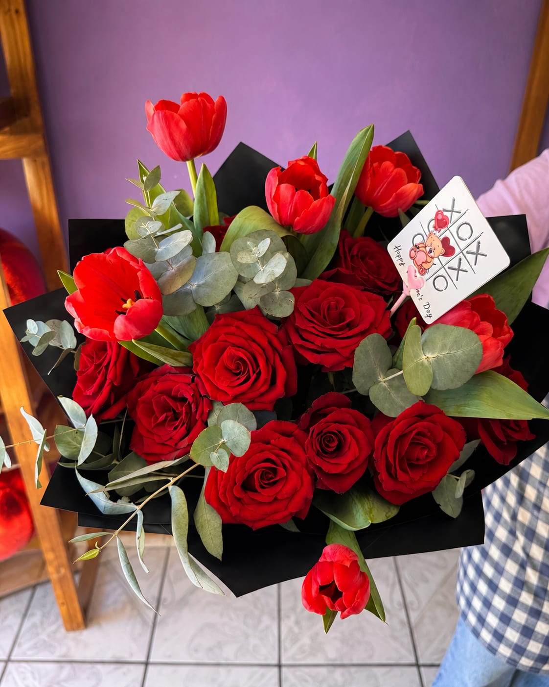 Red Roses &amp; Tulip Bouquet - A striking bouquet of deep red roses and red tulips with eucalyptus, wrapped in bold black paper. Dramatic, classic, and deeply romantic — ideal for declarations of love.