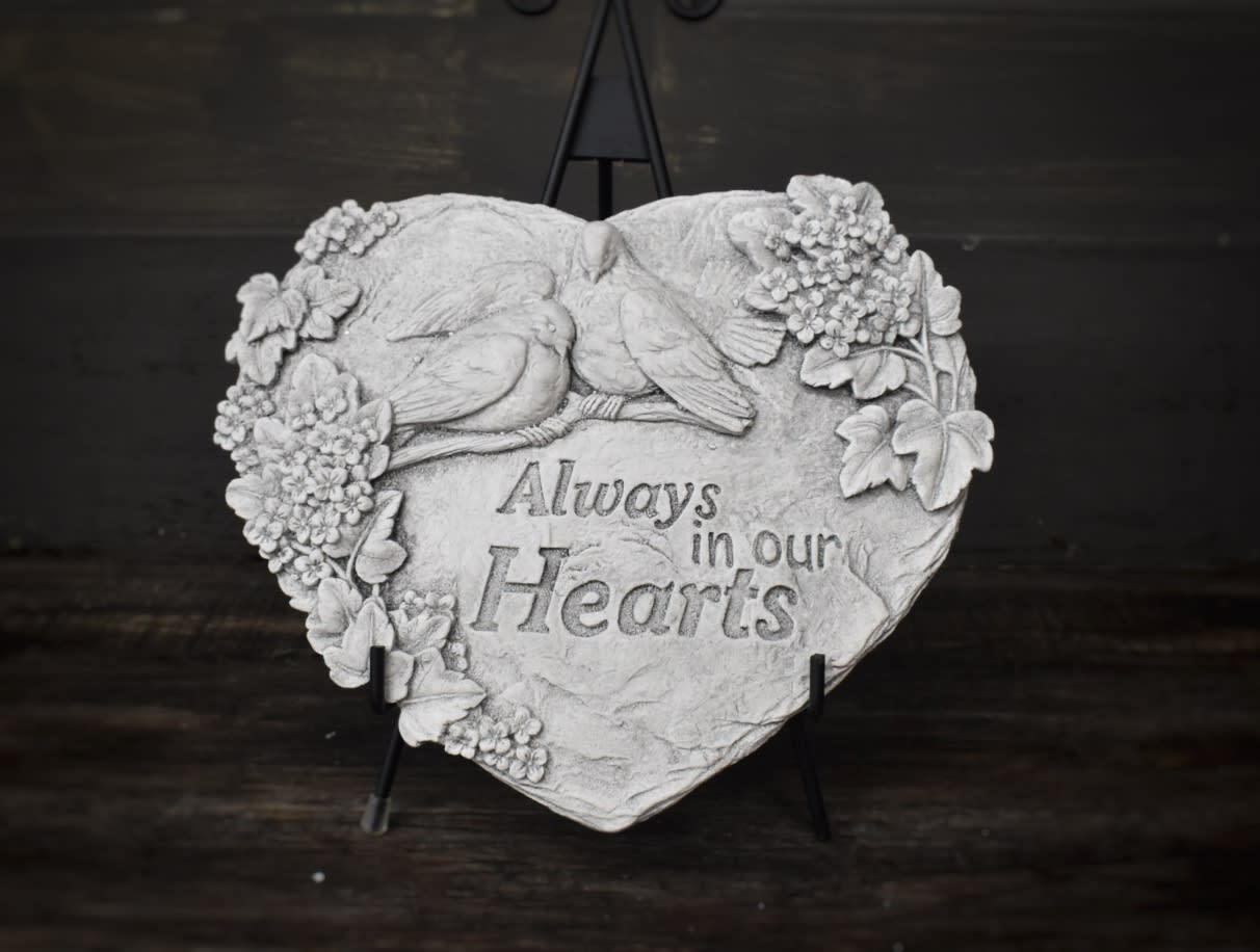 Heart-shaped memorial plaque with birds and flowers