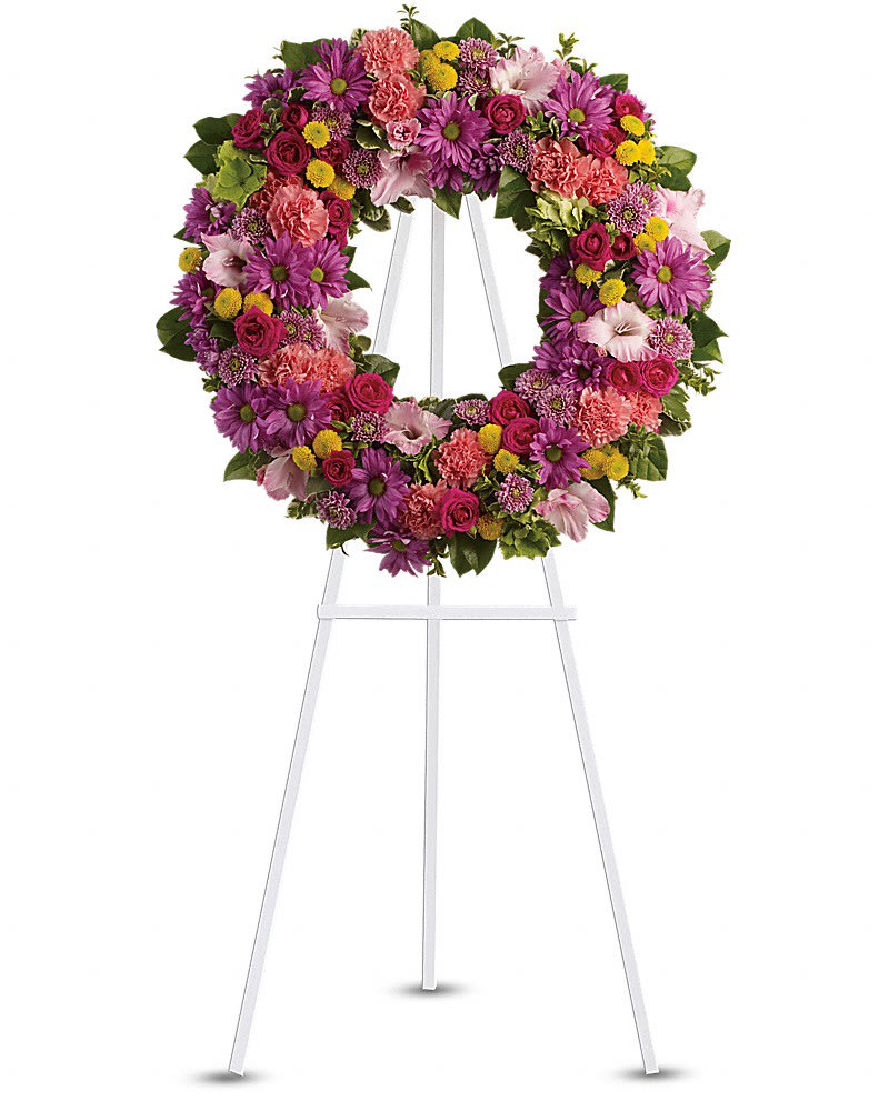 Ringed by Love - The memory of brighter days is always a comfort to those in mourning. This lovely wreath will display your compassion beautifully. A standing wreath of dazzling flowers such as green hydrangea, hot pink spray roses, pink gladioli and carnations along with a mÃ©lange of multi-colored daisy spray and cushion spray chrysanthemums and greenery is delivered on an easel.