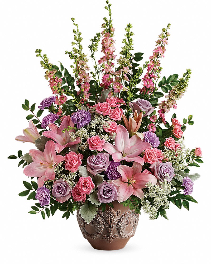 Teleflora's Soft Blush Bouquet - A touching tribute to a beloved woman, this beautiful, soft pink and lavender arrangement is presented in a large antiqued pot for an elegant touch. This soft pink arrangement features lavender roses, pink spray roses, pink asiatic lilies, lavender carnations, pink larkspur, queen anne's lace, huckleberry, dusty miller, and leatherleaf fern. Delivered in a Classical Garlands pot.