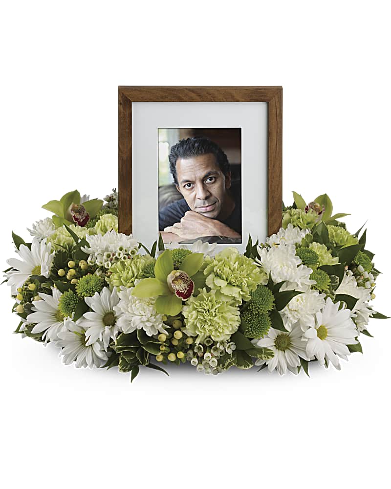 Garden Wreath - An exquisite round wreath with blooms inspired by the lasting impressions a loved one makes on our lives. Surround a treasured photograph, poem or other dear memento with sweet, green carnations, white and green chrysanthemums and the special beauty of green cymbidium orchids. This luxurious wreath includes flowers such as carnations, chrysanthemums, silky green cymbidium orchid blossoms and variegated greenery. Please note: Arrangement does not include picture frame.
