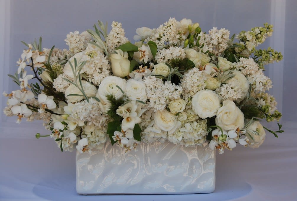 White floral arrangement in a glossy rectangular vase