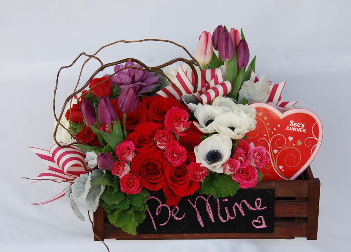 Be Mine - A little garden of white french anemones, pink spray roses, red roses, and tulips. The arrangement is accented with beautiful greens, Anniversary, Valentin's Day, I Love You ribbons and Chocolates.   