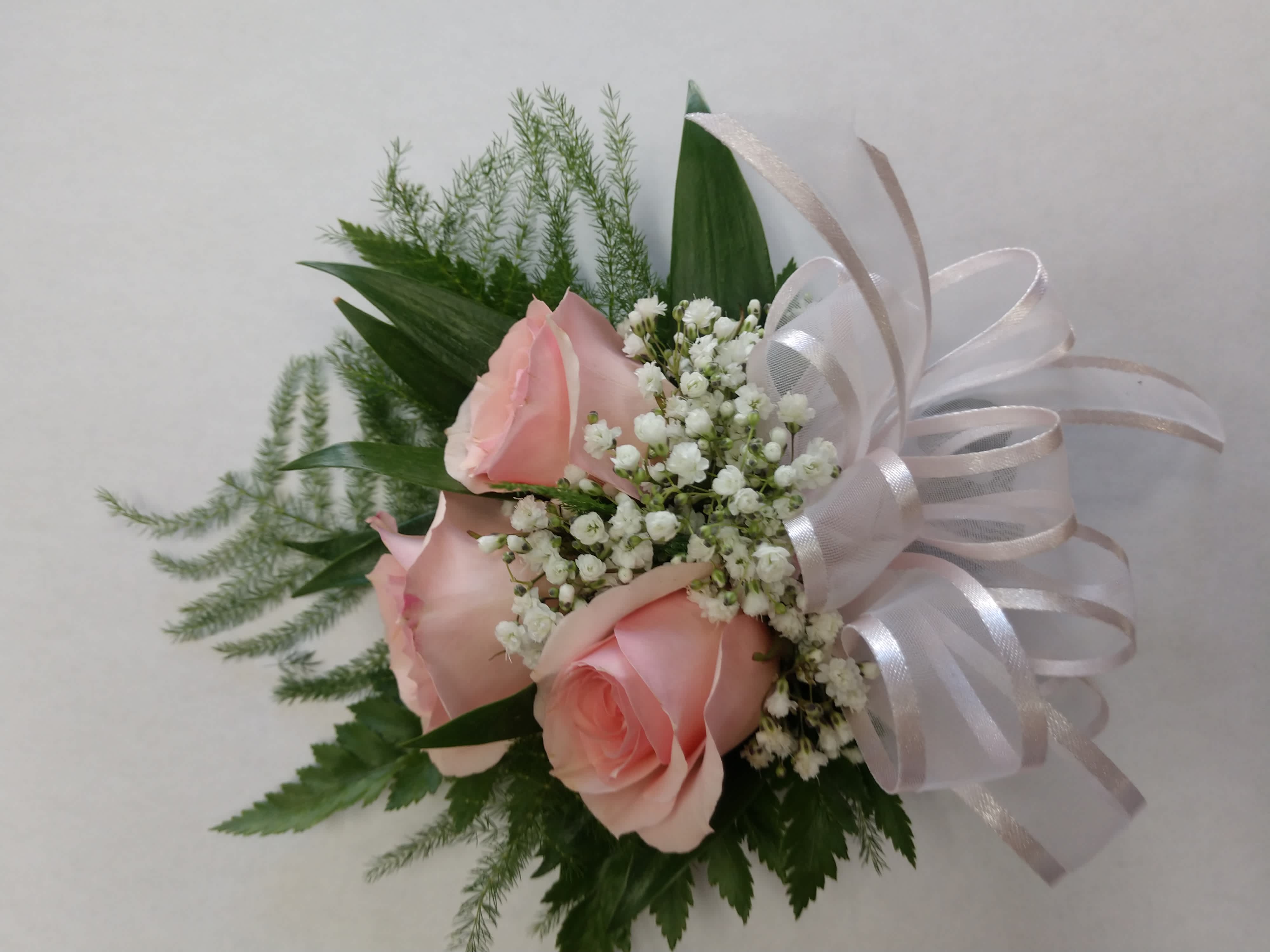Pink roses with baby's breath and a white ribbon bow