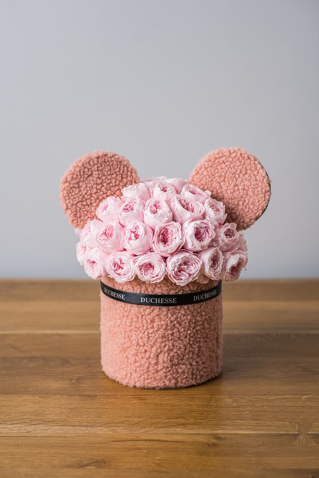Pink rose bouquet arranged in a teddy bear-shaped box