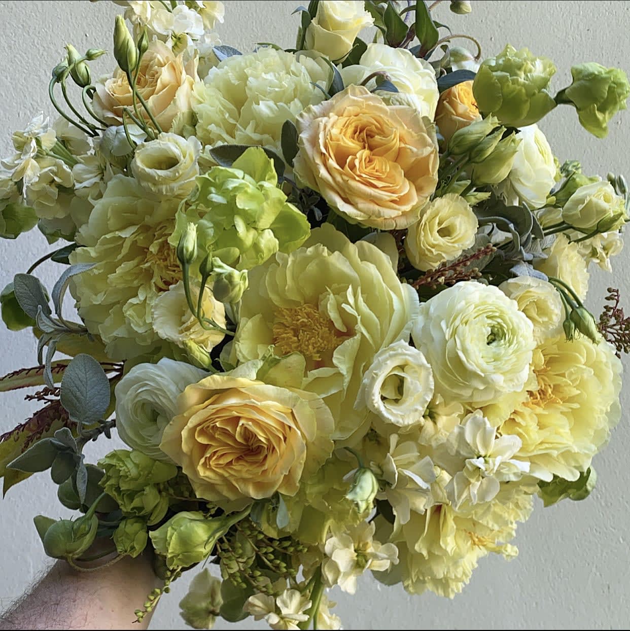 Bouquet of pale yellow and white flowers with green accents