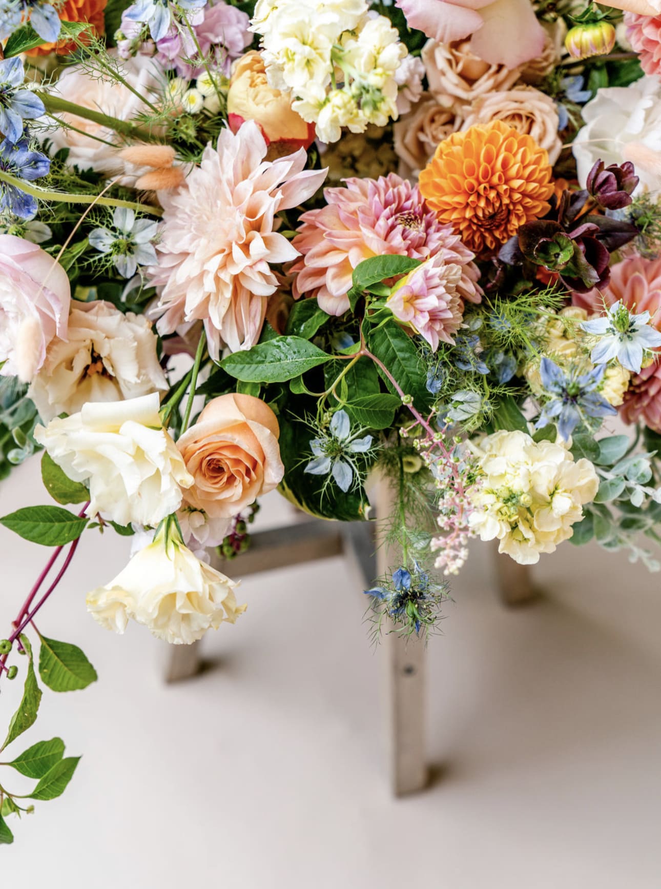 Mixed pastel bouquet with roses, dahlias, and small blue flowers