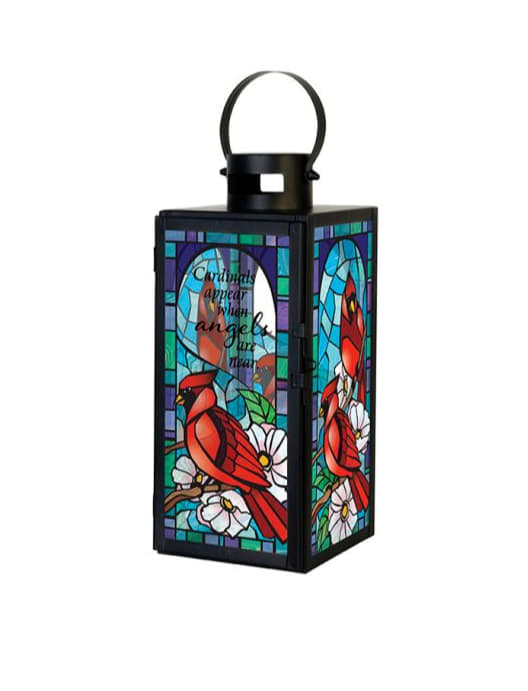 Black metal lantern with stained-glass cardinal and white flowers in bright jewel tones.