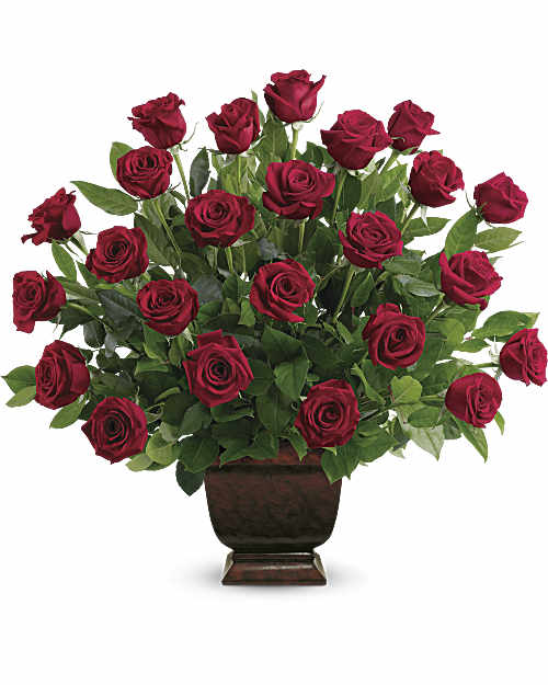 Red roses arranged in a dark pedestal vase