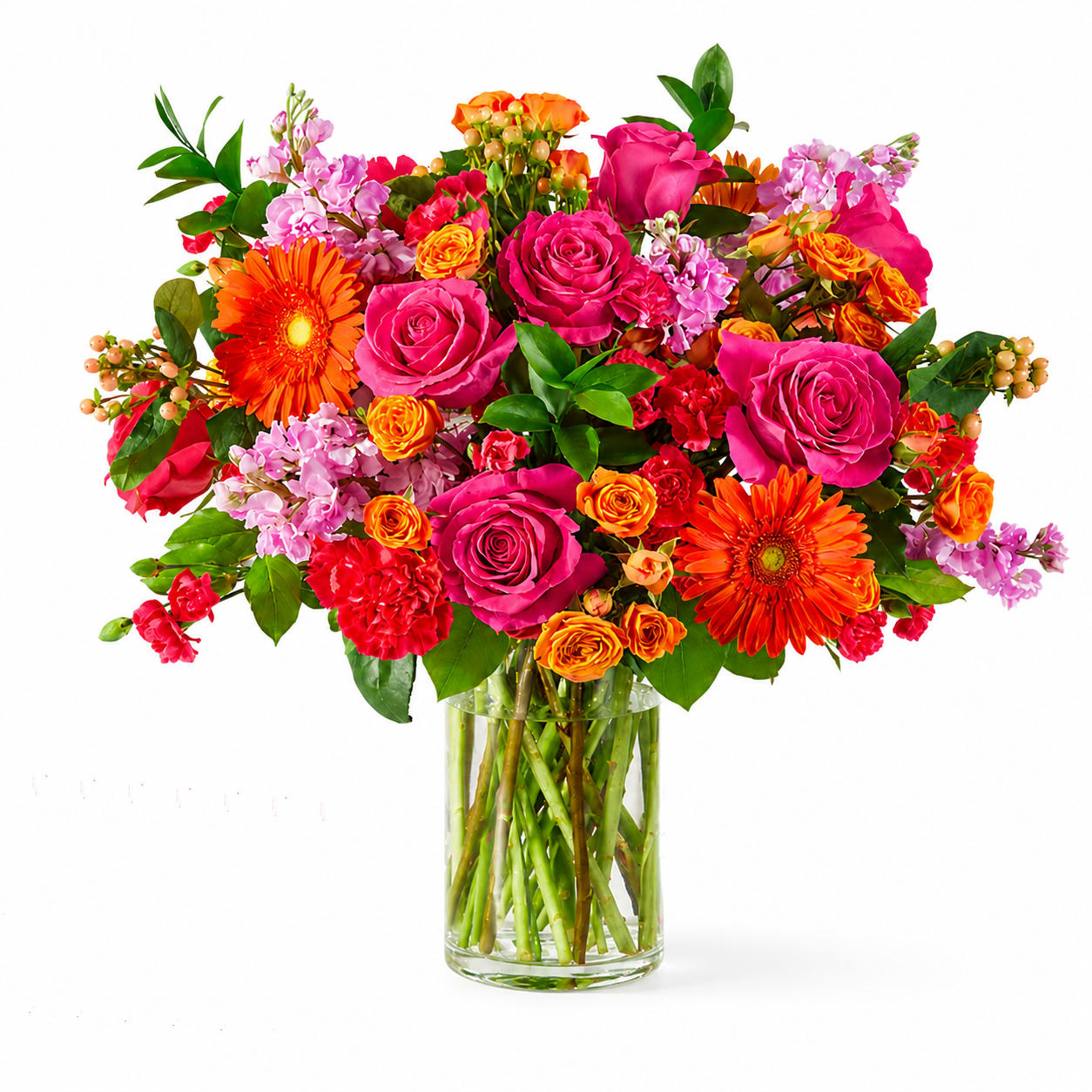 Mixed bouquet of pink and orange flowers in a clear glass vase