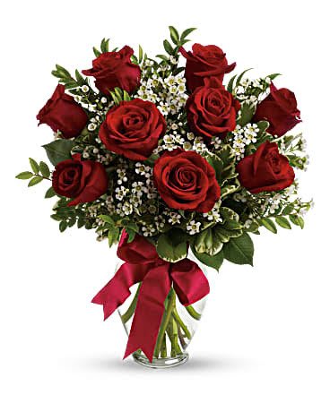 Bouquet of red roses with white filler flowers in a glass vase